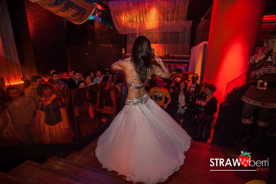 Bailarina de danza del vientre en carnavales en el bar Strawberry con vestido blanco