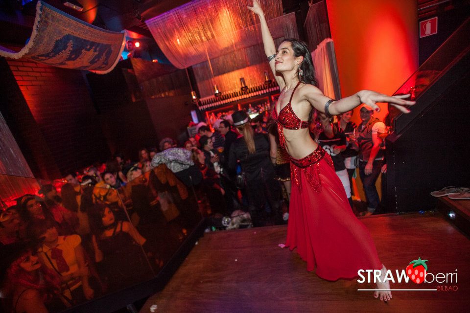 Bailarina de danza oriental en carnavales en el bar Strawberry con vestido rojo